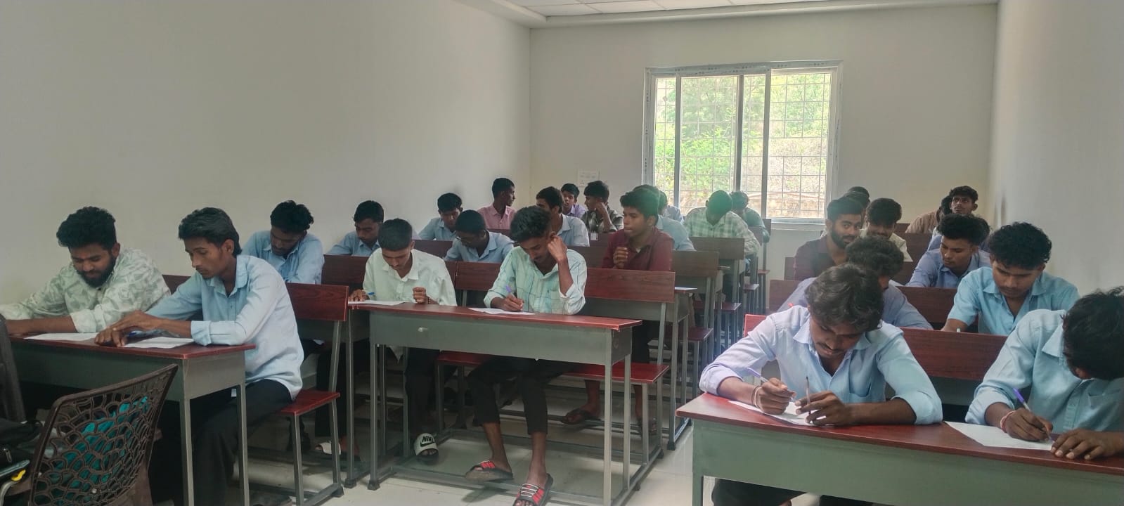 Students focused on writing during classroom exam session